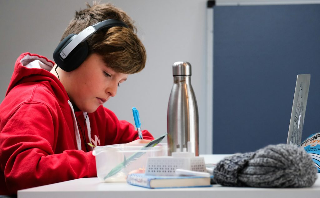 ADHD-Student doing homework with headphones on.