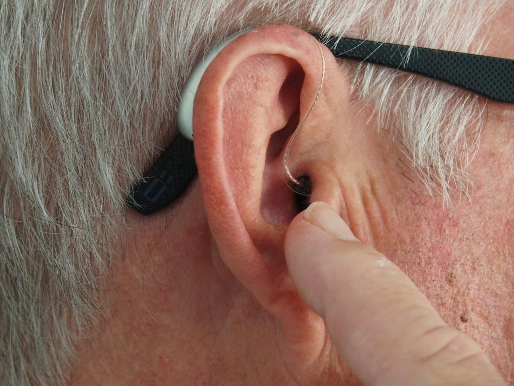 A man pointing to his ear.